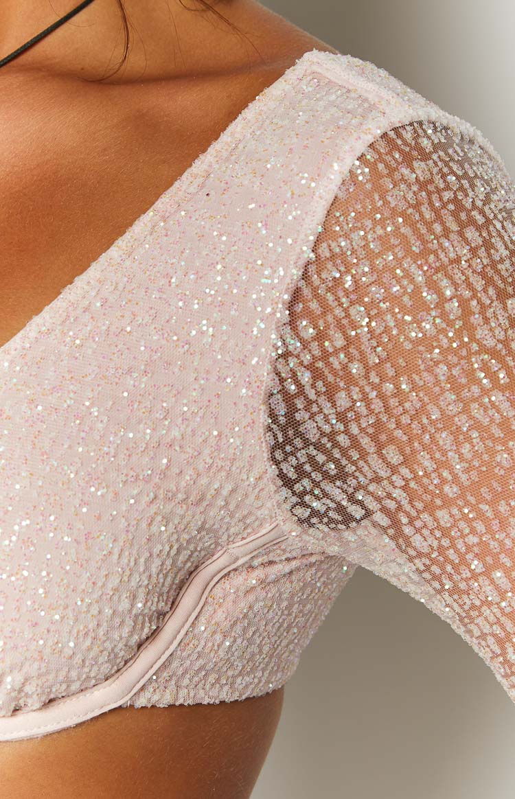 Close-up of the pink sequin crop top showing the sheer mesh long sleeve and shimmering texture