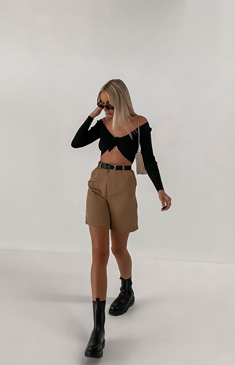 Tan high-waisted shorts with a relaxed fit, pleated front, and black belt detail