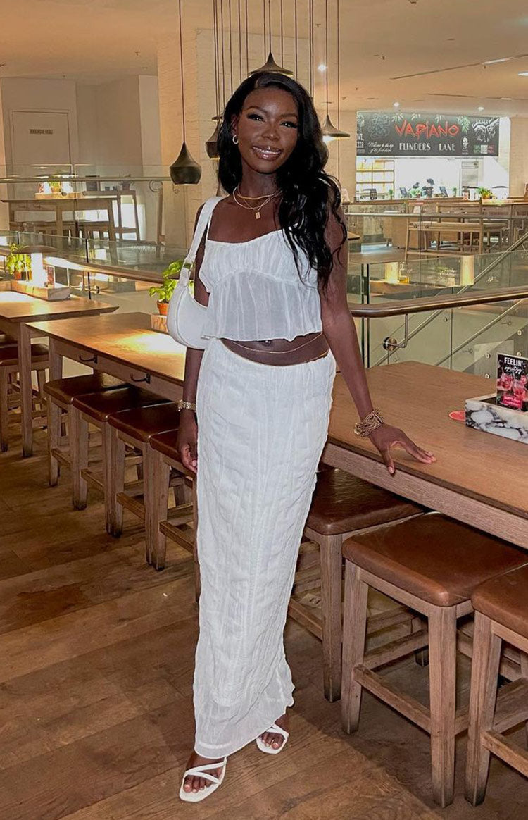 White crinkled maxi skirt with a fitted waist and straight cut, extending to the floor